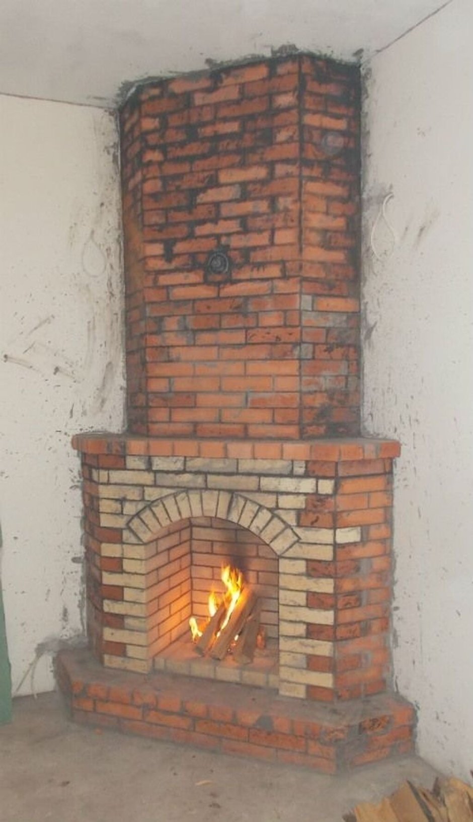 Небольшой угловой камин из кирпича