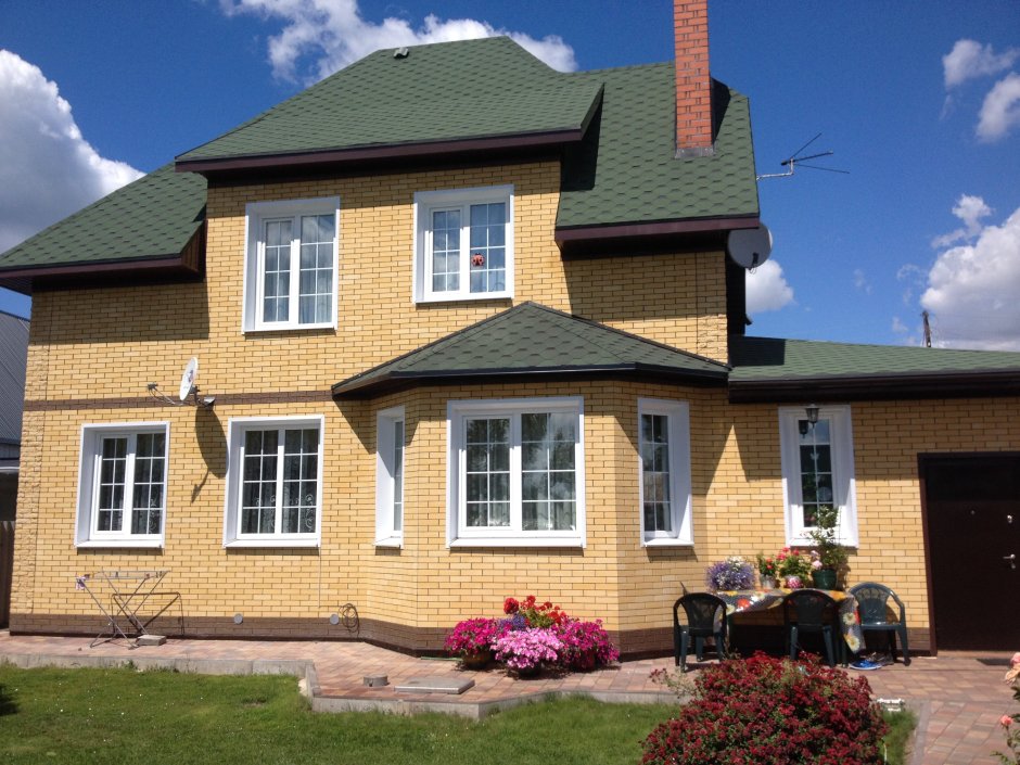 Кирпичный дом с зеленой крышей