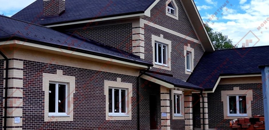 Дом из коричневого кирпича с белыми окнами