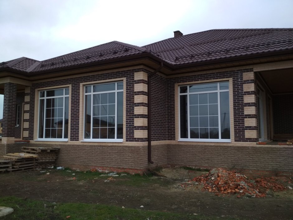 Дом из коричневого кирпича с белыми окнами