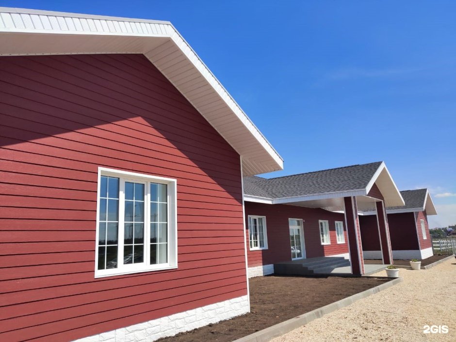 Дом с бордовой крышей и сайдингом